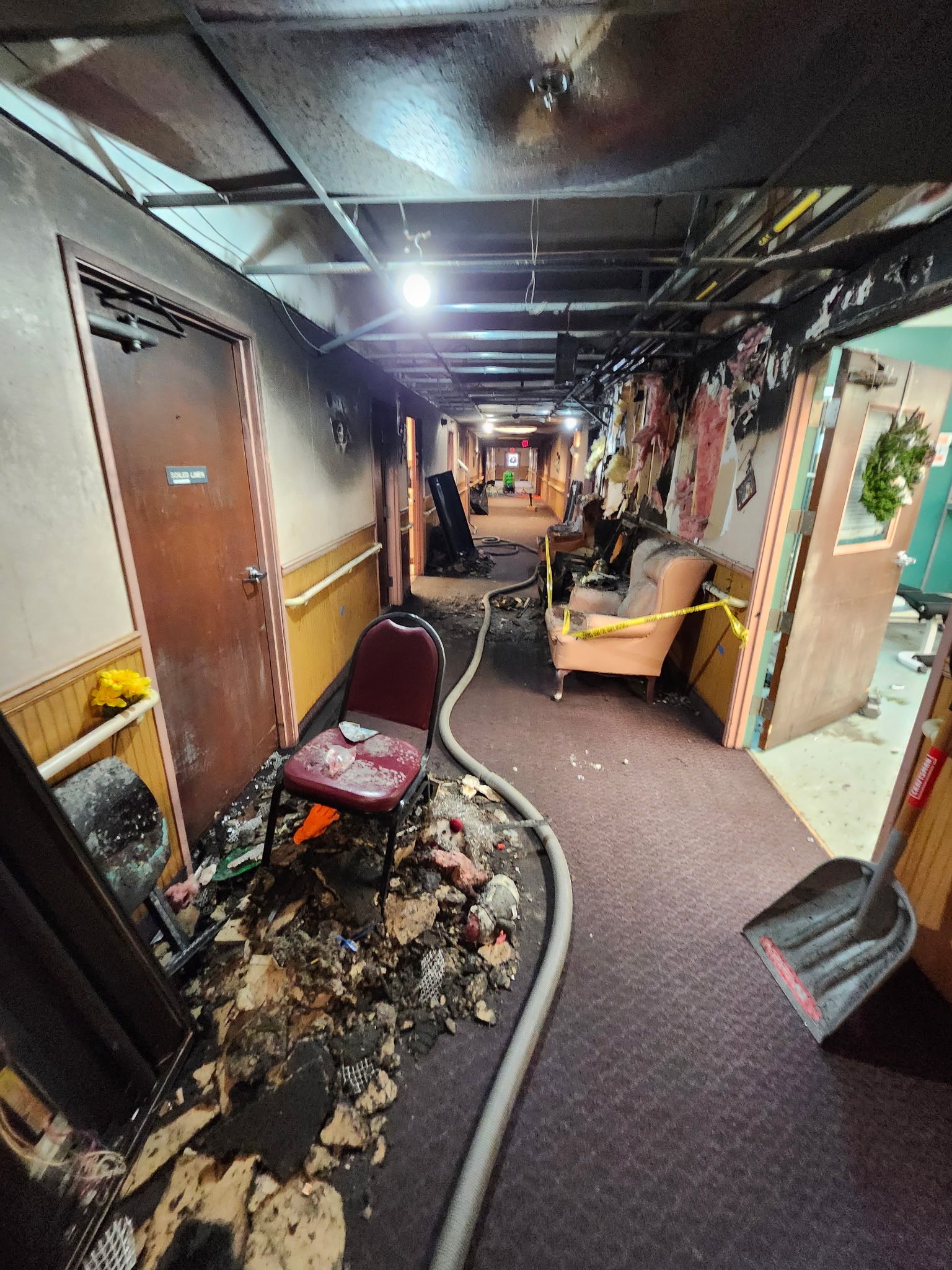 Corridor before restoration: fire and smoke damage throughout the hallway