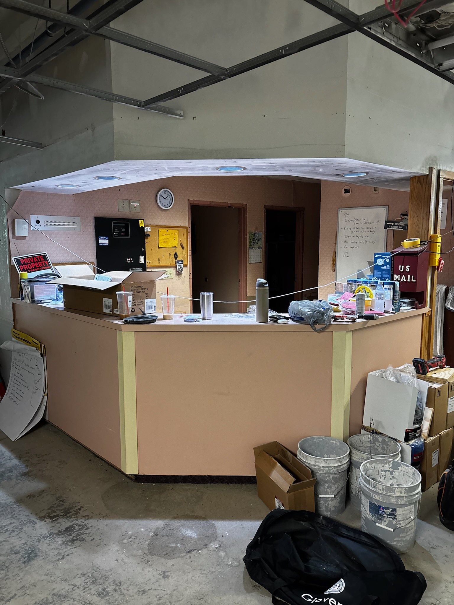 Nurses station before renovation: bare plywood desk in a stripped-out room